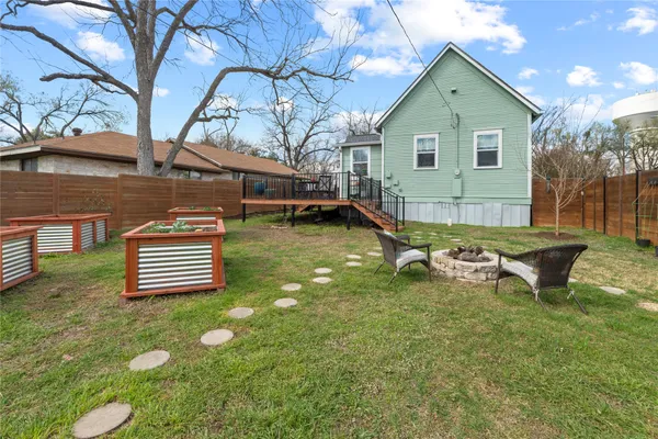 a backyard of a house with barbeque oven and outdoor seating