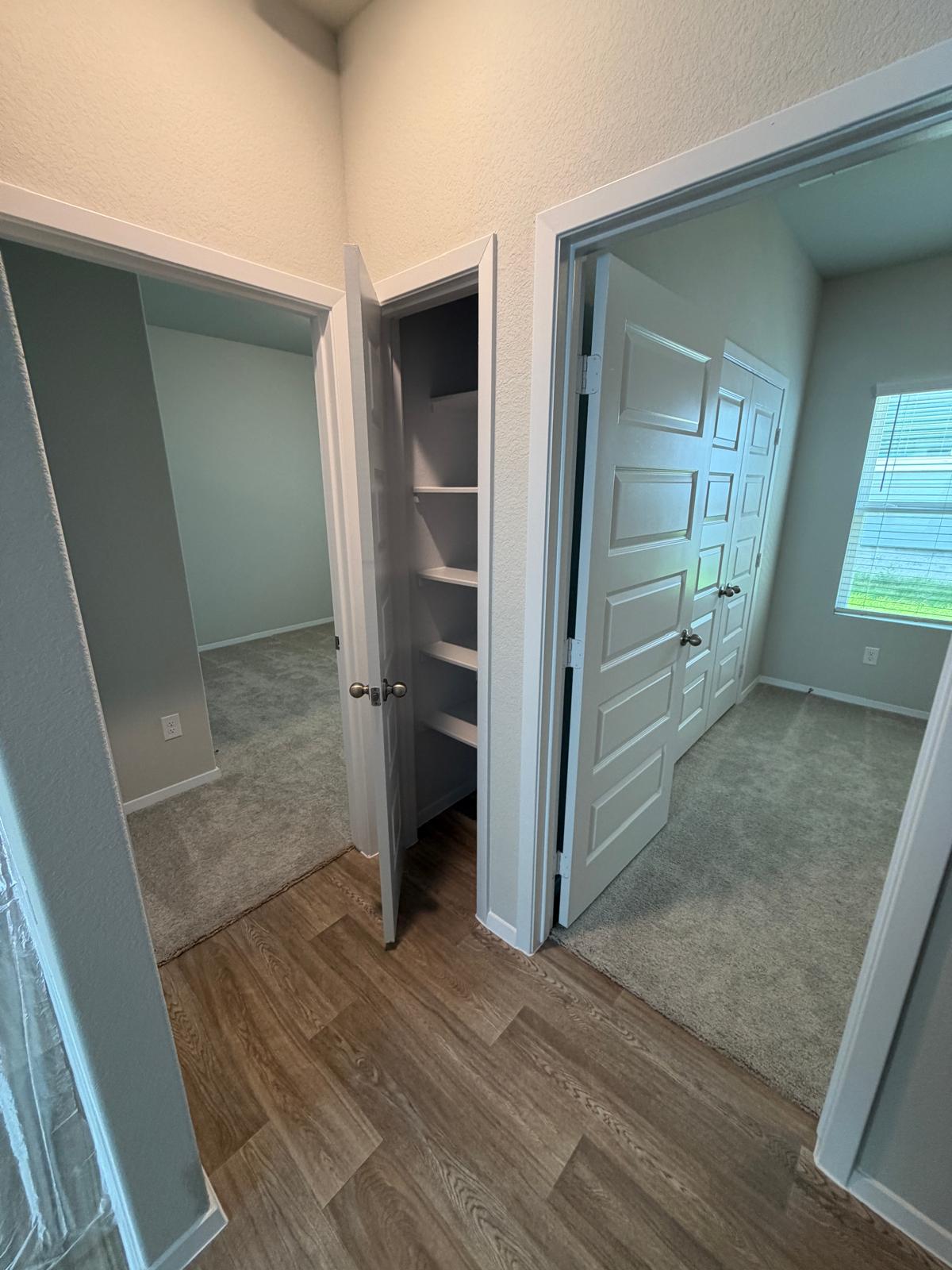 2701 Towy Road Manor, TX 78653 - Photo 15 of 35 Find spacious, carpeted bedrooms flowing into a main hall with easy-care flooring and built-in shelving.