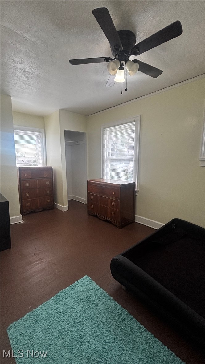 15710 Hazel Road Cleveland, OH 44112 - Photo 19 of 44 Carpeted bedroom featuring a textured ceiling, baseboards, a ceiling fan, and a closet