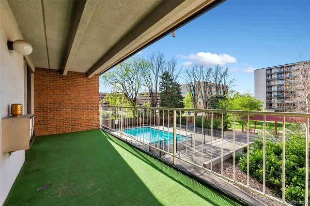 a view of a balcony with floor to ceiling windows with wooden fence