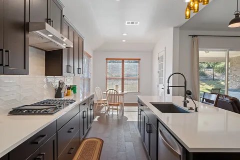a kitchen with a sink a stove and chairs