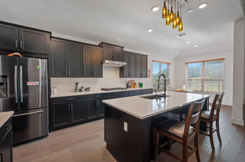 a kitchen with a stove a sink a refrigerator and a refrigerator