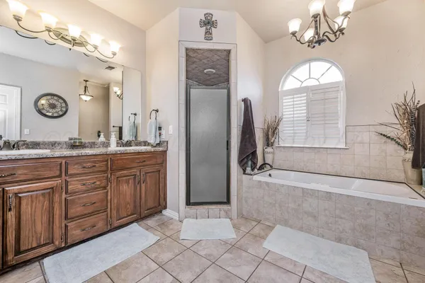 a spacious bathroom with a granite countertop sink mirror and a bathtub with shower