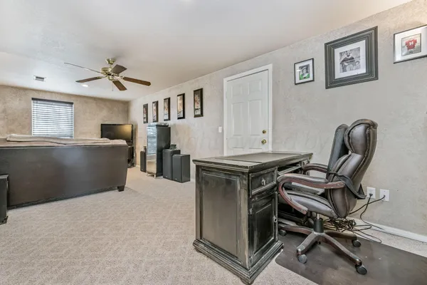 a workspace with furniture and ceiling fan