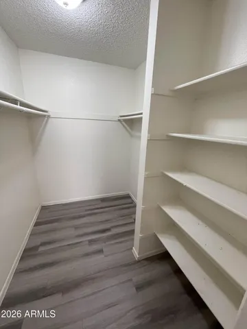 a view of walk in closet with empty racks