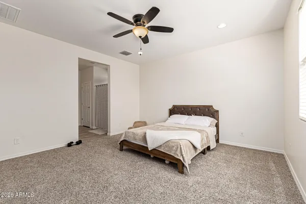 a spacious bedroom with a bed and a ceiling fan