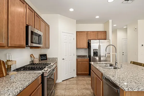 a kitchen with stainless steel appliances granite countertop a sink stove and refrigerator