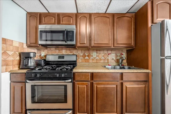 a kitchen with stainless steel appliances granite countertop a refrigerator and a microwave
