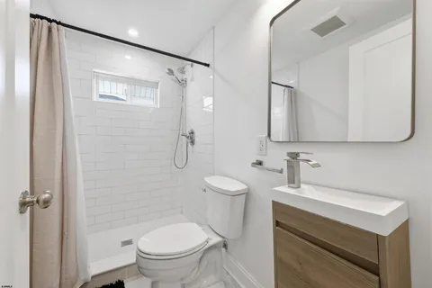 a bathroom with a sink a toilet and shower