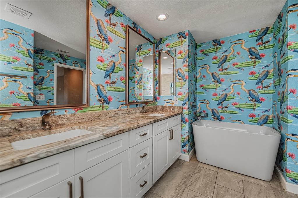 159 April Road Rotonda West, FL 33947 - Photo 38 of 73 a bathroom with a sink a vanity and a large mirror with painted walls