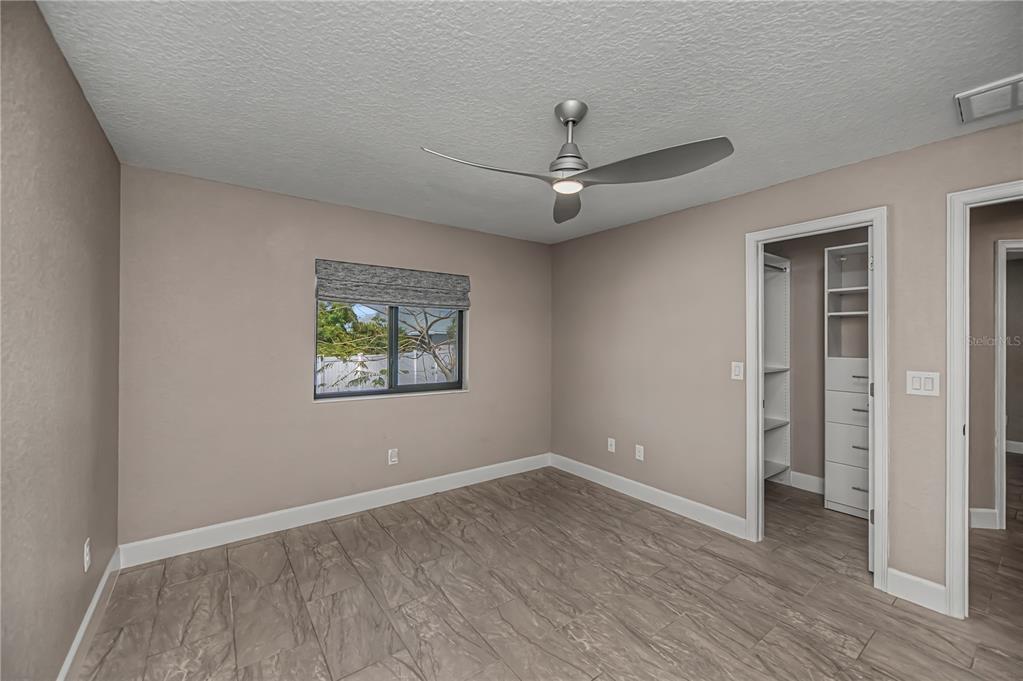 159 April Road Rotonda West, FL 33947 - Photo 44 of 73 an empty room with wooden floor chandelier fan and windows