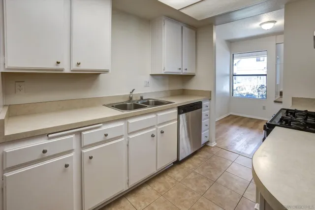 a kitchen with granite countertop white cabinets and white appliances
