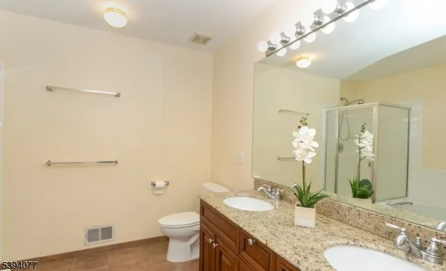 a bathroom with a granite countertop sink toilet and shower