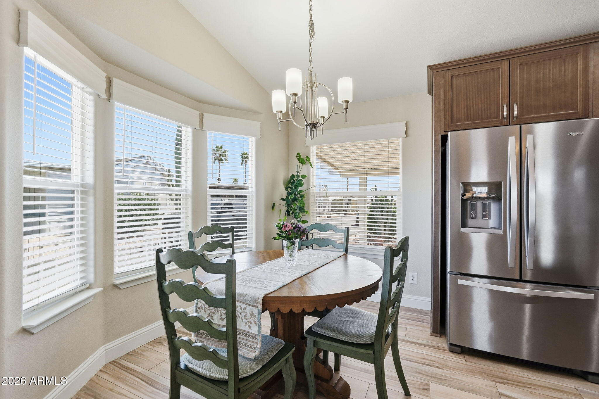 8865 East Baseline Road, Unit 1417 Mesa, AZ 85209 - Photo 12 of 47 a dining room with furniture a chandelier and wooden floor
