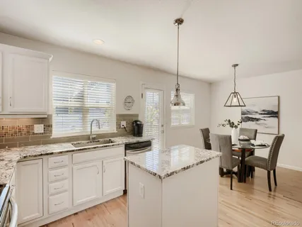 a kitchen with a sink a stove a dining table and chairs