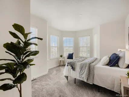 a bedroom with bed and a potted plant