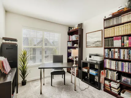 a view of a workspace with furniture and a book shelf