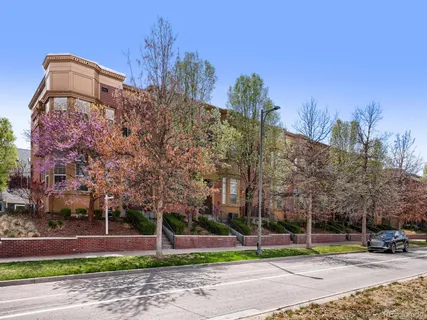a view of a building with a yard and large trees