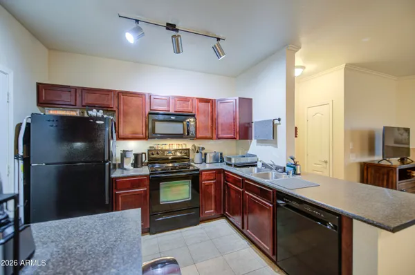 a kitchen with stainless steel appliances granite countertop a refrigerator a stove a sink and a refrigerator