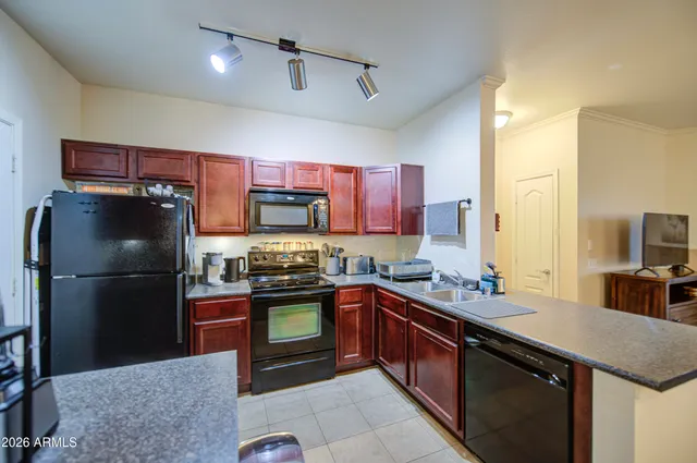 a kitchen with stainless steel appliances granite countertop a refrigerator a stove a sink and a refrigerator