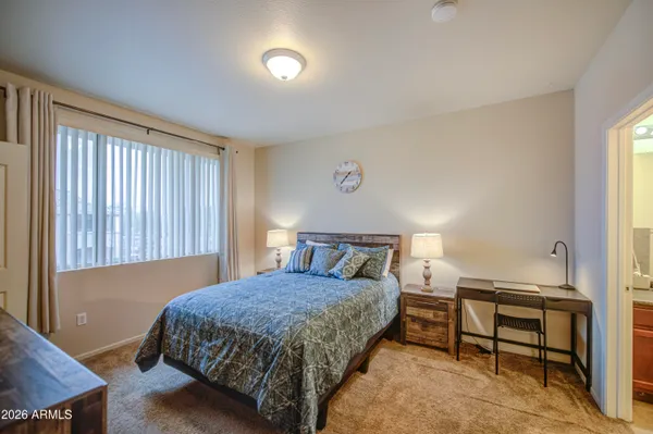 a bedroom with a large bed and a chandelier
