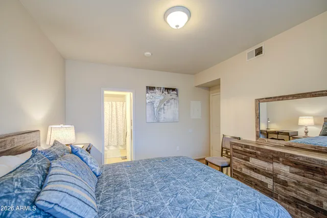 a bedroom with a bed and wooden floor