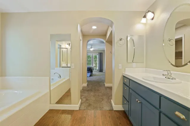 a spacious bathroom with a bathtub sink and mirror