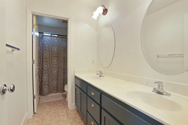 a bedroom with a bed and a chandelier fan