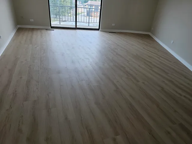 a view of a room with wooden floor and a window