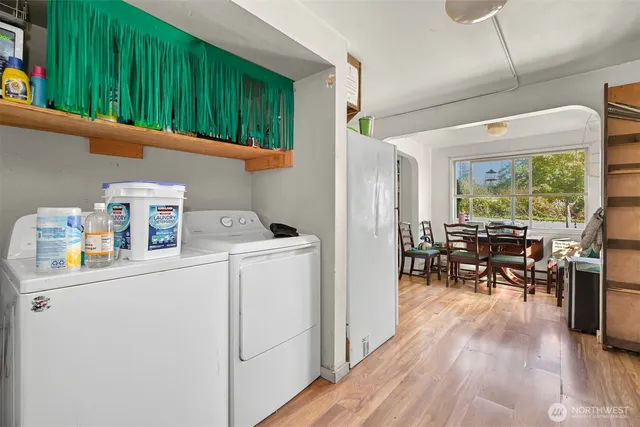 a utility room with dryer washer and a view of living room