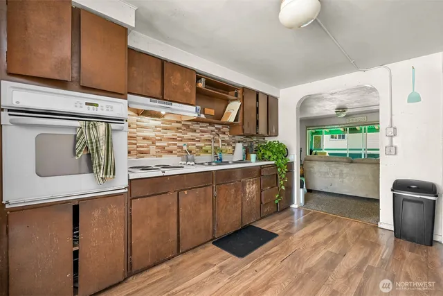 a kitchen with stainless steel appliances granite countertop a refrigerator a stove and a wooden floors