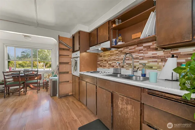 a kitchen with appliances cabinets and wooden floor