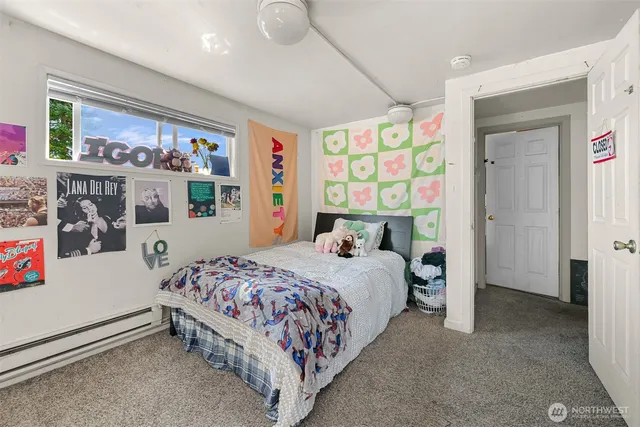 a bedroom with a bed painting on wall and a window