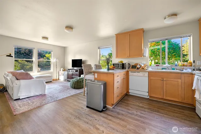a kitchen with a sink a counter top space and living room area