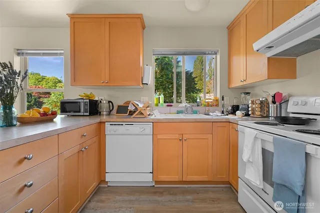 a kitchen with stainless steel appliances white cabinets and a window