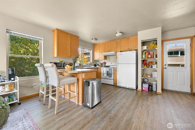 a kitchen with a table chairs refrigerator and cabinets