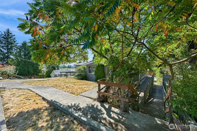 a backyard of a house with table and chairs under an umbrella