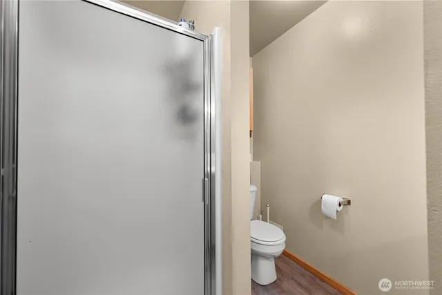 a bathroom with a granite countertop toilet and a shower