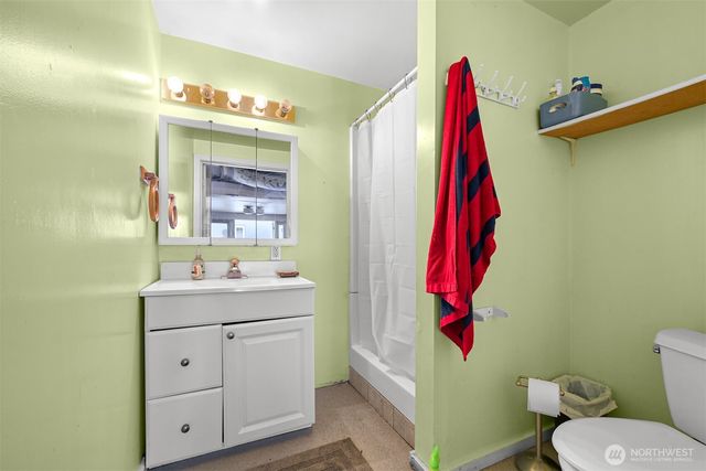 a bathroom with a sink vanity mirror and toilet
