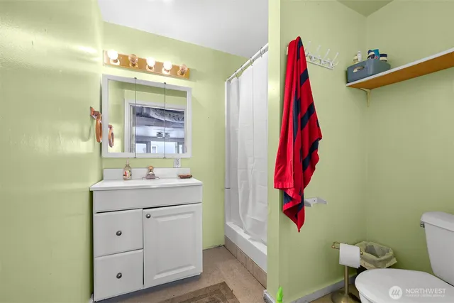 a bathroom with a sink vanity mirror and toilet