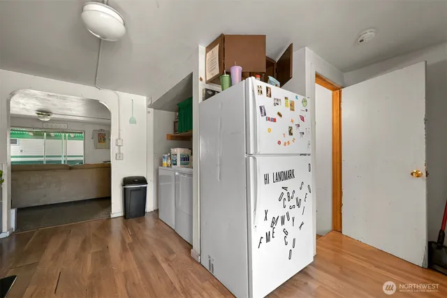a kitchen with stainless steel appliances a refrigerator and a wooden floor