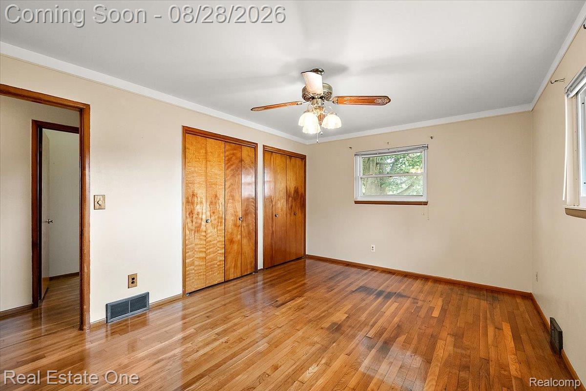 15250 34 Mile Road Armada, MI 48005 - Photo 40 of 49 Hardwood flooring, dual wood-paneled closets, ceiling fan with integrated lighting, and crown molding