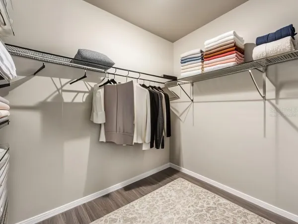 a view of walk in closet with clothes and shoes