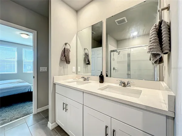 a en suite bathroom with a double vanity sink and a mirror