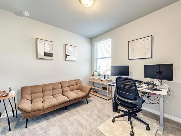 a livingroom with workspace and a couch