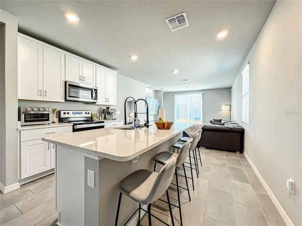 a kitchen with a sink a microwave a refrigerator and cabinets