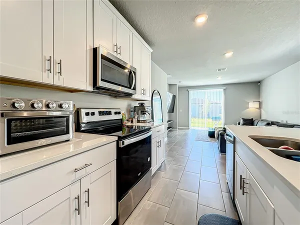 a kitchen with stainless steel appliances granite countertop a stove a sink and a microwave