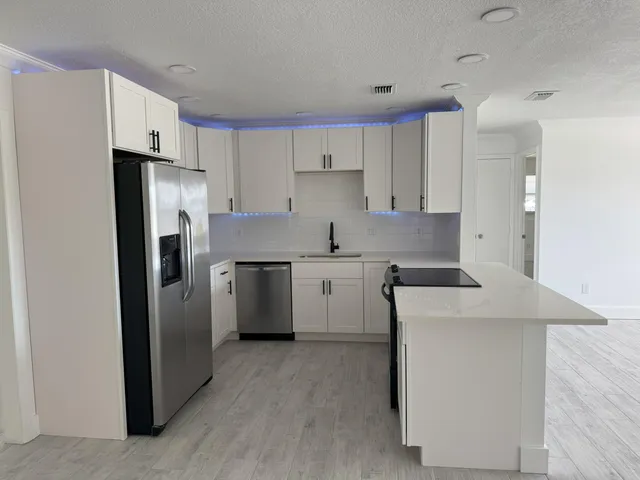 a kitchen with stainless steel appliances a refrigerator sink and cabinets