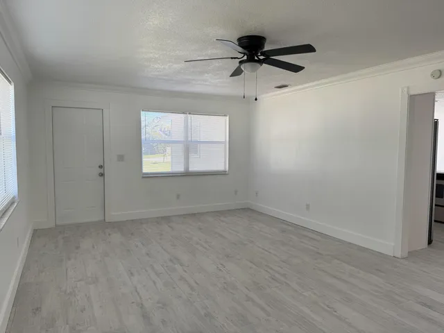 an empty room with a window and a ceiling fan