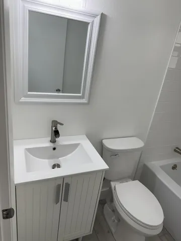 a bathroom with a toilet sink and mirror